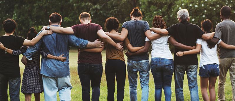 People with their backs turned with arms around each other